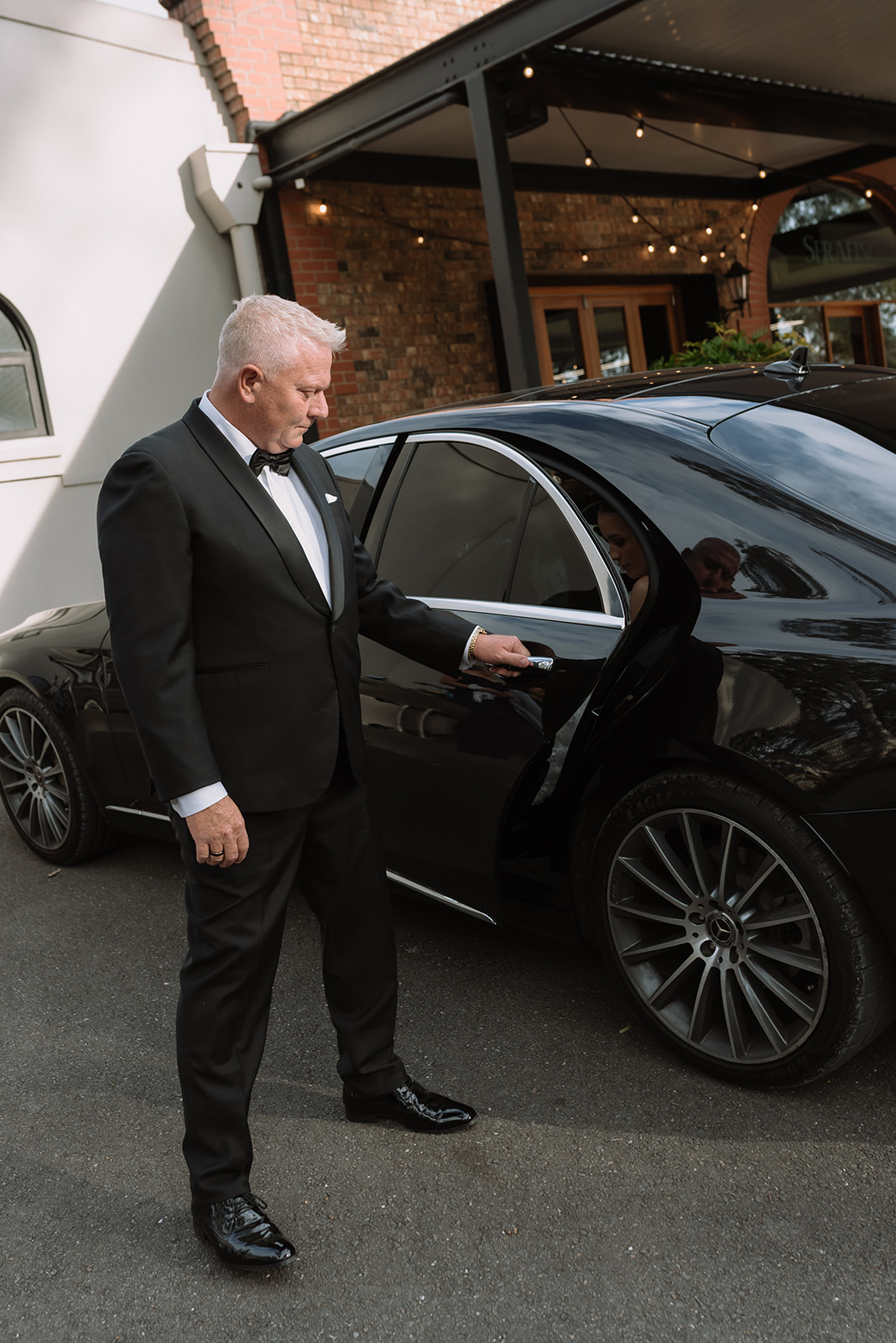 Chauffeur opening door of Mercedes S Class at venue